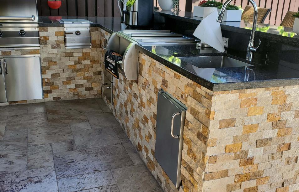 Outdoor kitchen made of stainless steel, bricks and marble