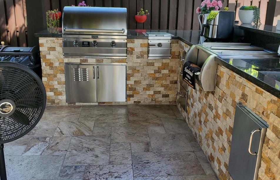 Outdoor kitchen made of stainless steel, bricks and marble