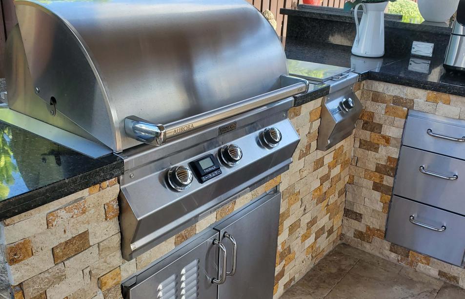 Outdoor kitchen made of stainless steel, bricks and marble